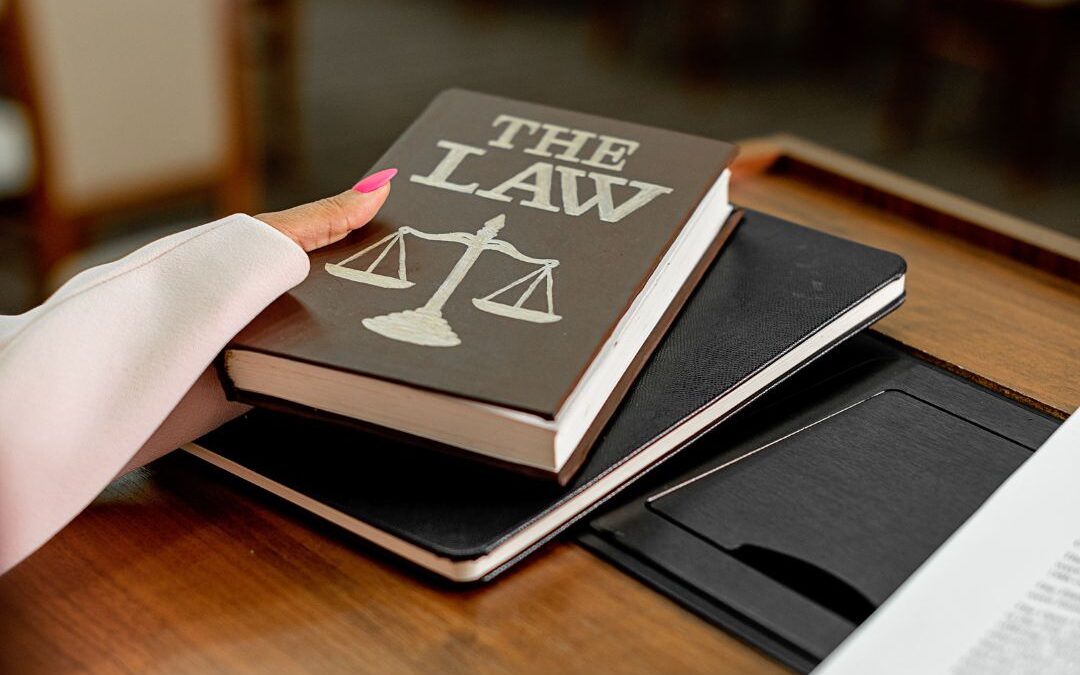 Law book with scales of justice symbol on desk representing workplace harassment laws and legal protections in Nassau and Suffolk County.