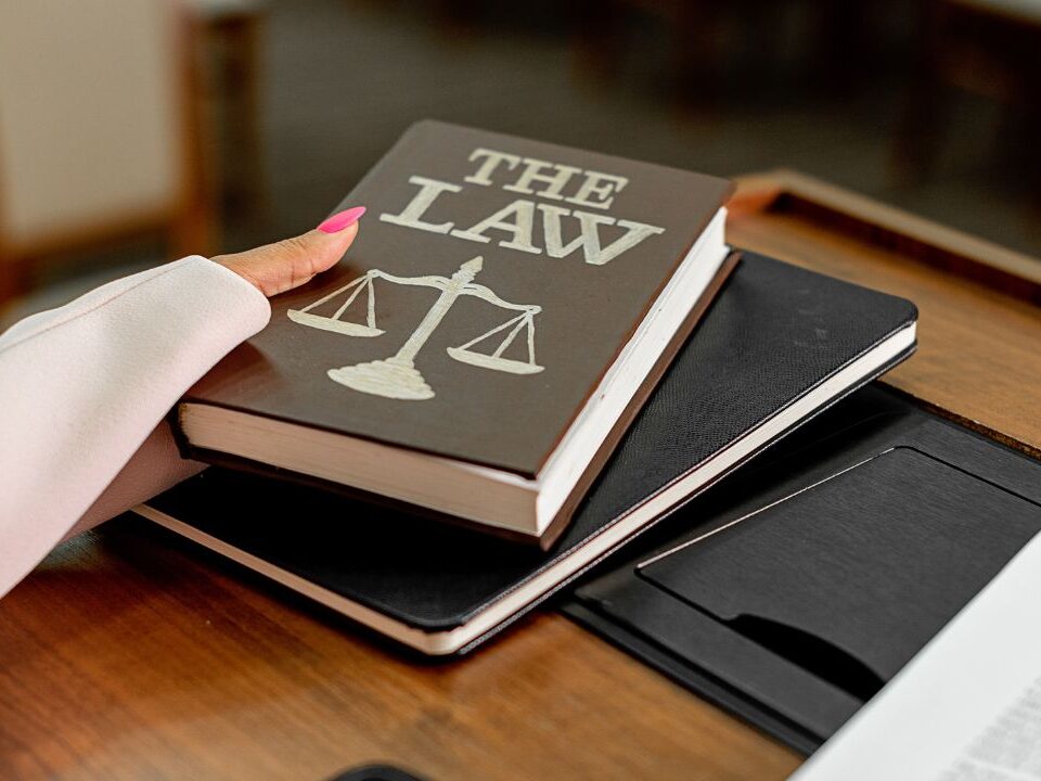Law book with scales of justice symbol on desk representing workplace harassment laws and legal protections in Nassau and Suffolk County.