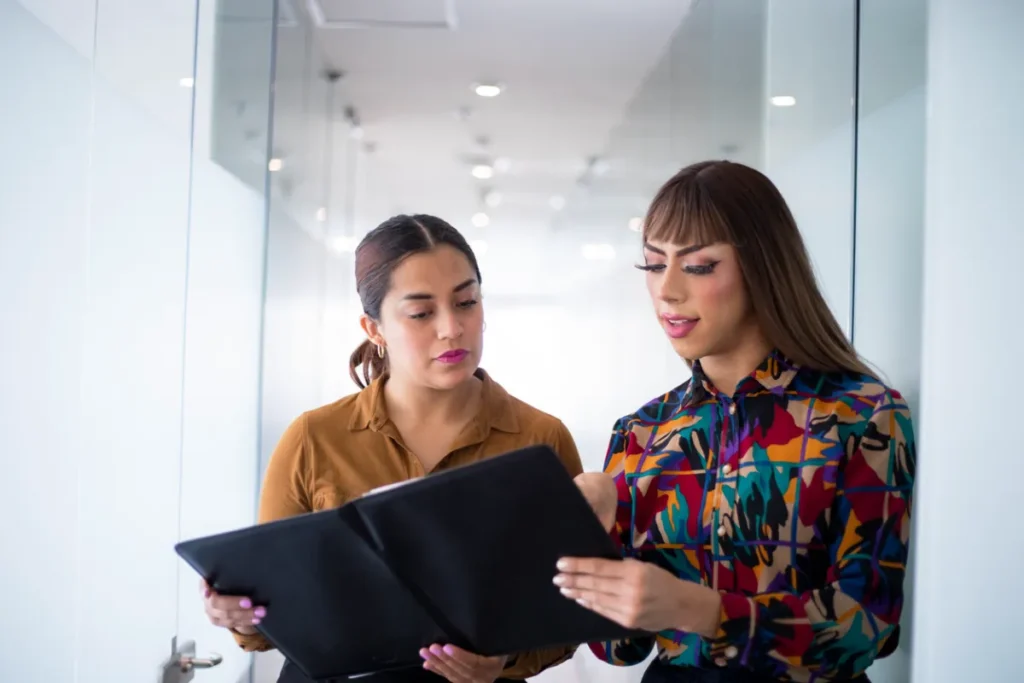 Employees discussing workplace concerns related to gender identity discrimination in a New York office