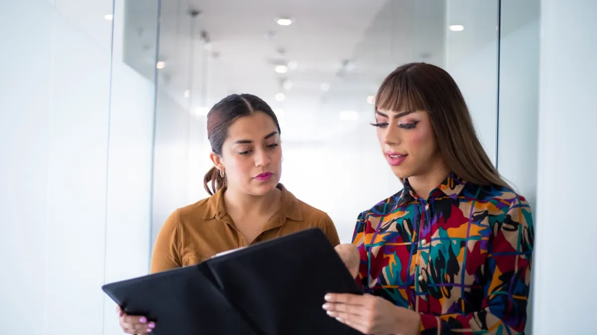 Employees discussing workplace concerns related to gender identity discrimination in a New York office